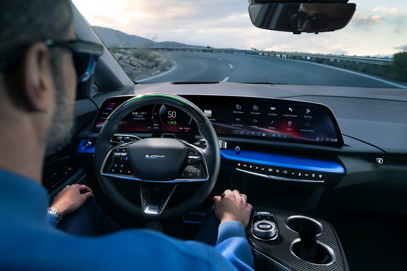 Front View of the 2026 OPTIQ-V Driving Through the Dusk Utilizing its Headlights | Fred Anderson Cadillac in Greer SC